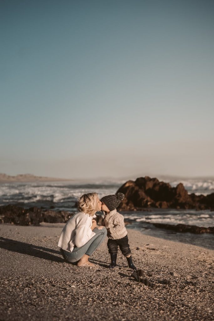 photo of woman kissing toddler