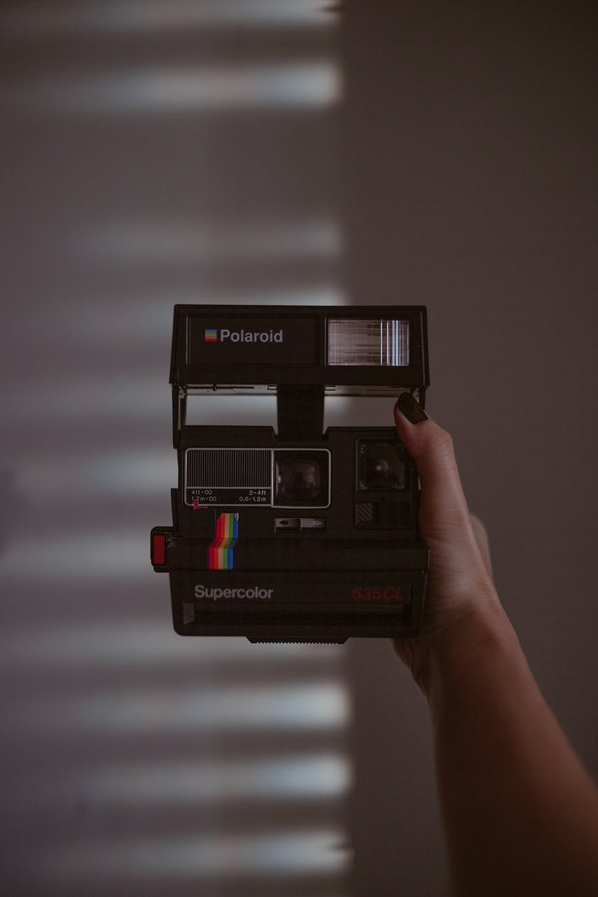 person holding black polaroid instant camera