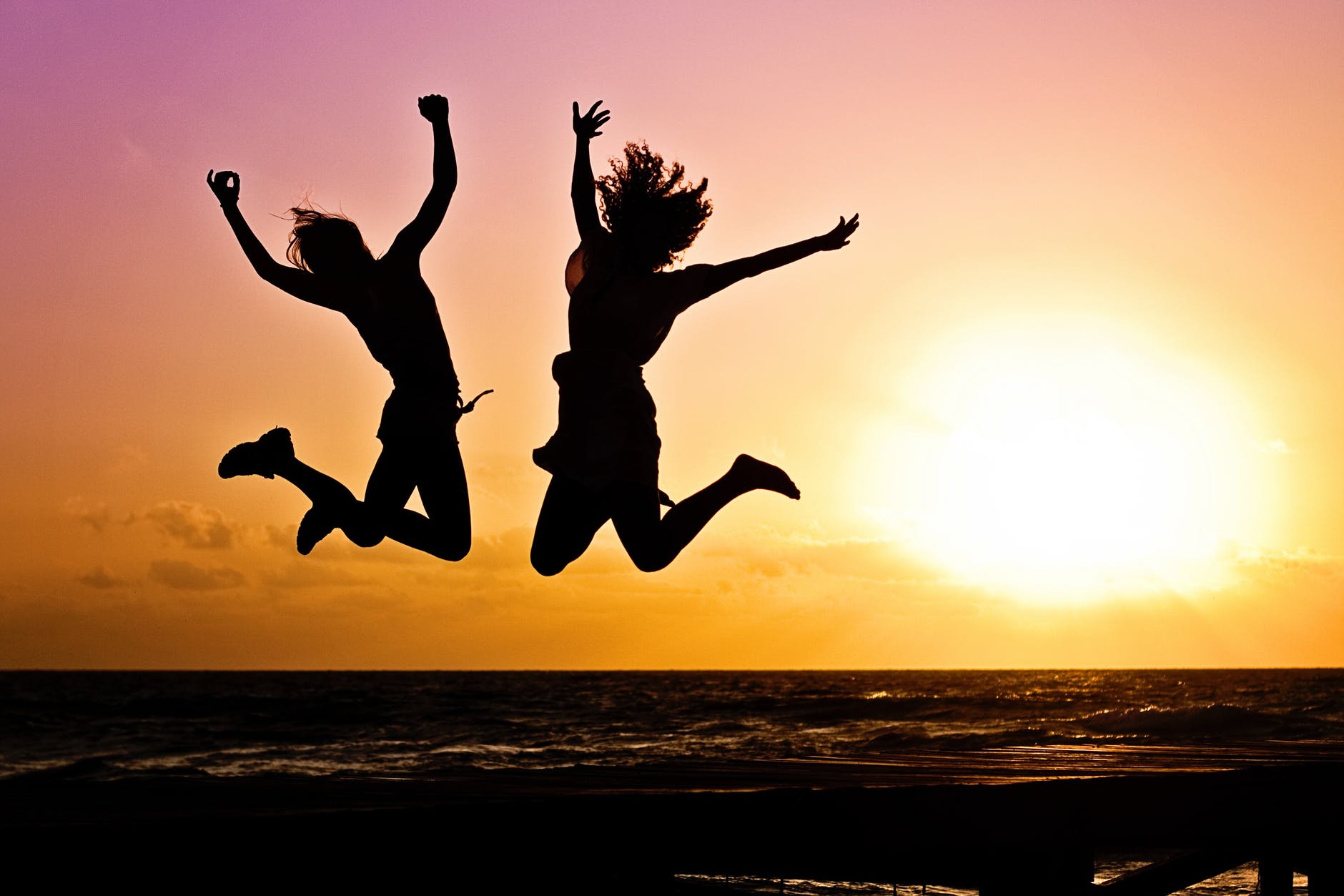 silhouette photography of jump shot of two persons