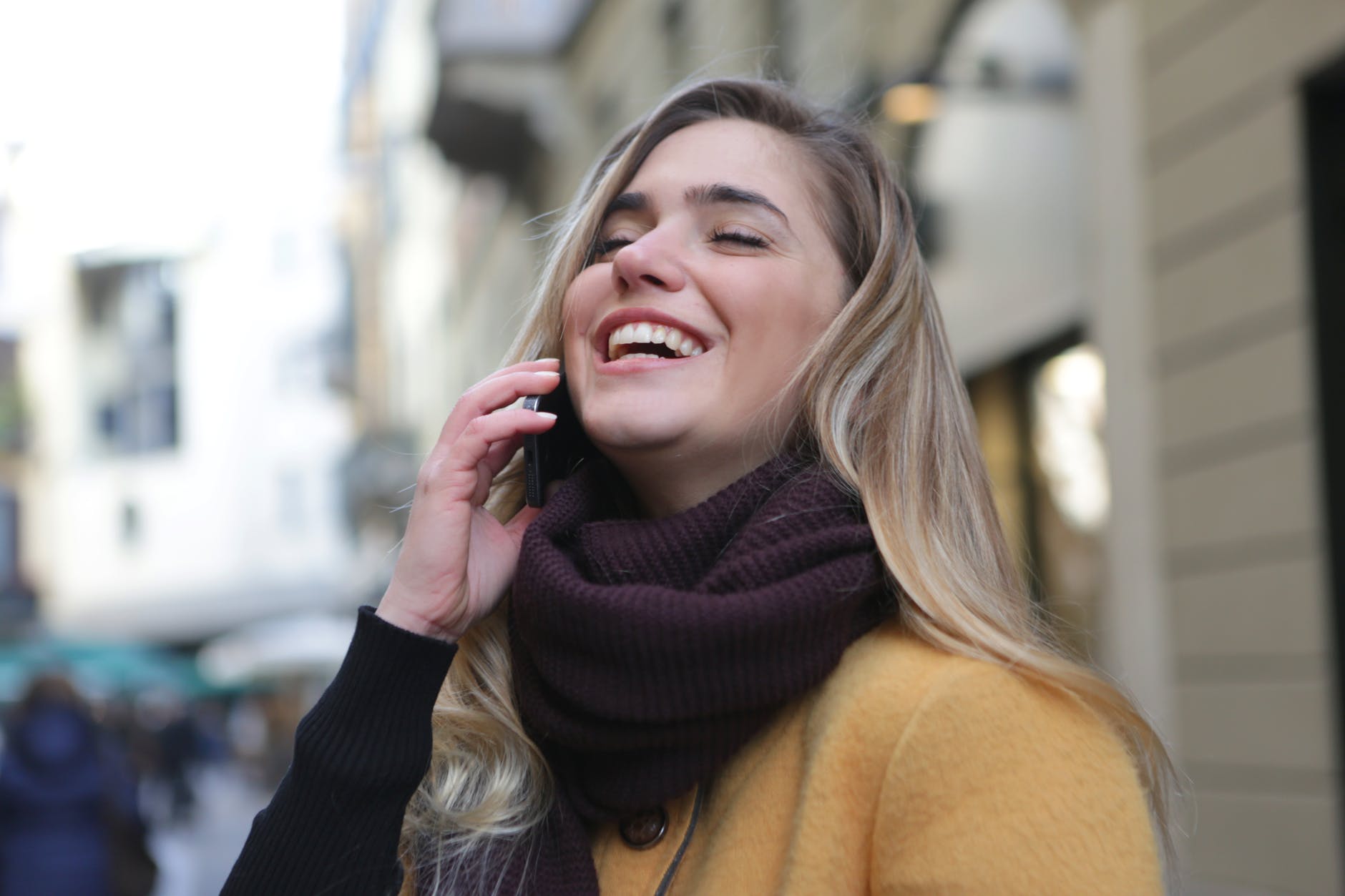 joyful woman in purple scarf and brown coat