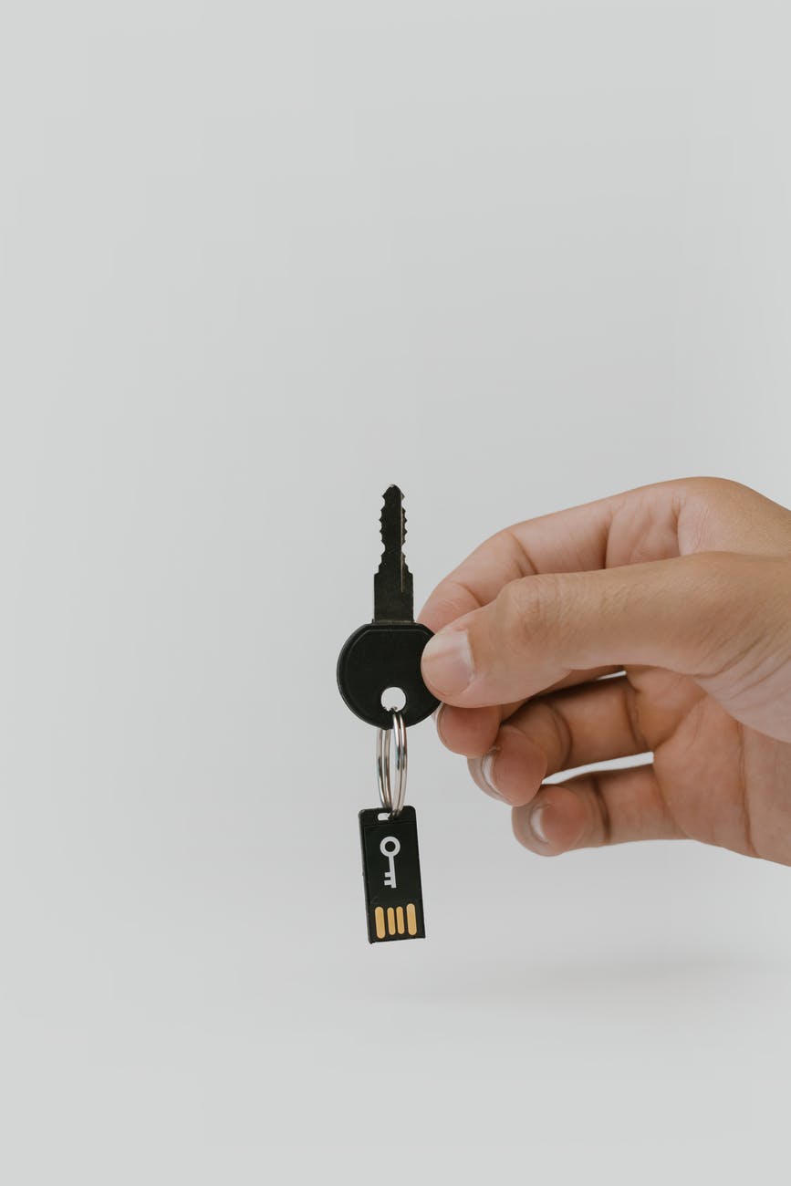 hand holding a key with a usb flash drive