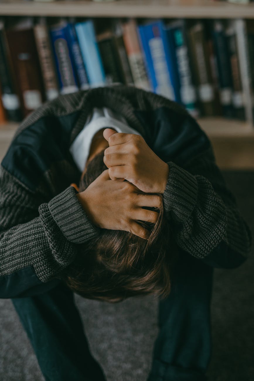 a person holding hair with head down