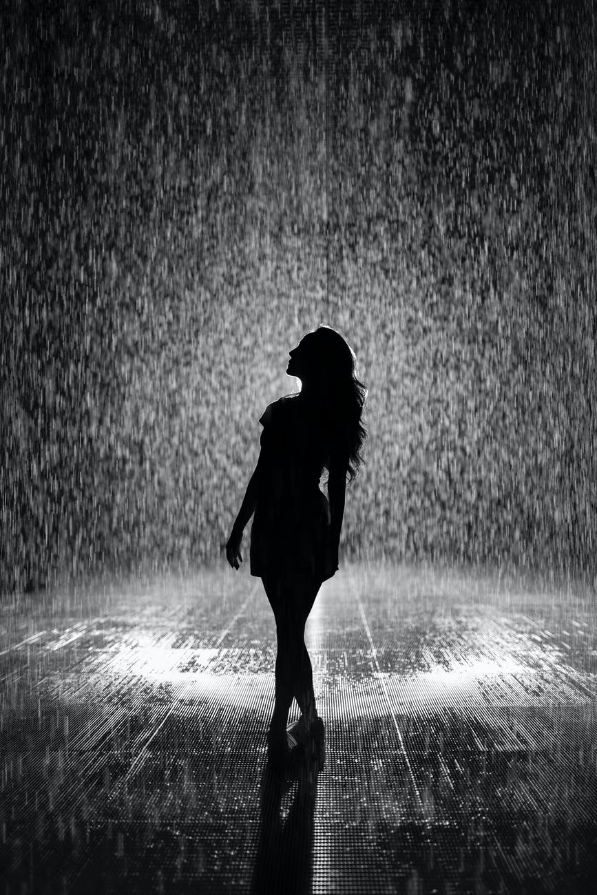 silhouette of woman under rain