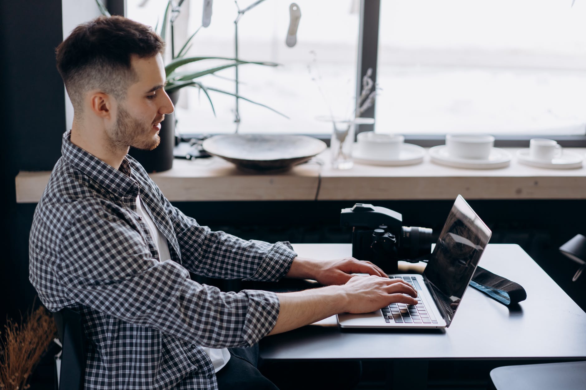 man in black and white plaid long sleeve shirt using laptop