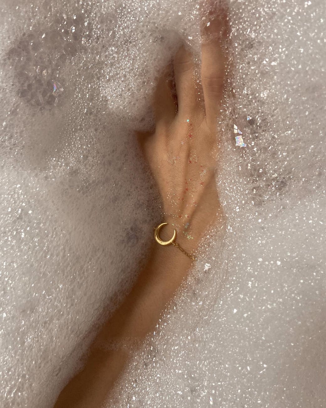 woman with bracelet taking bath with foam