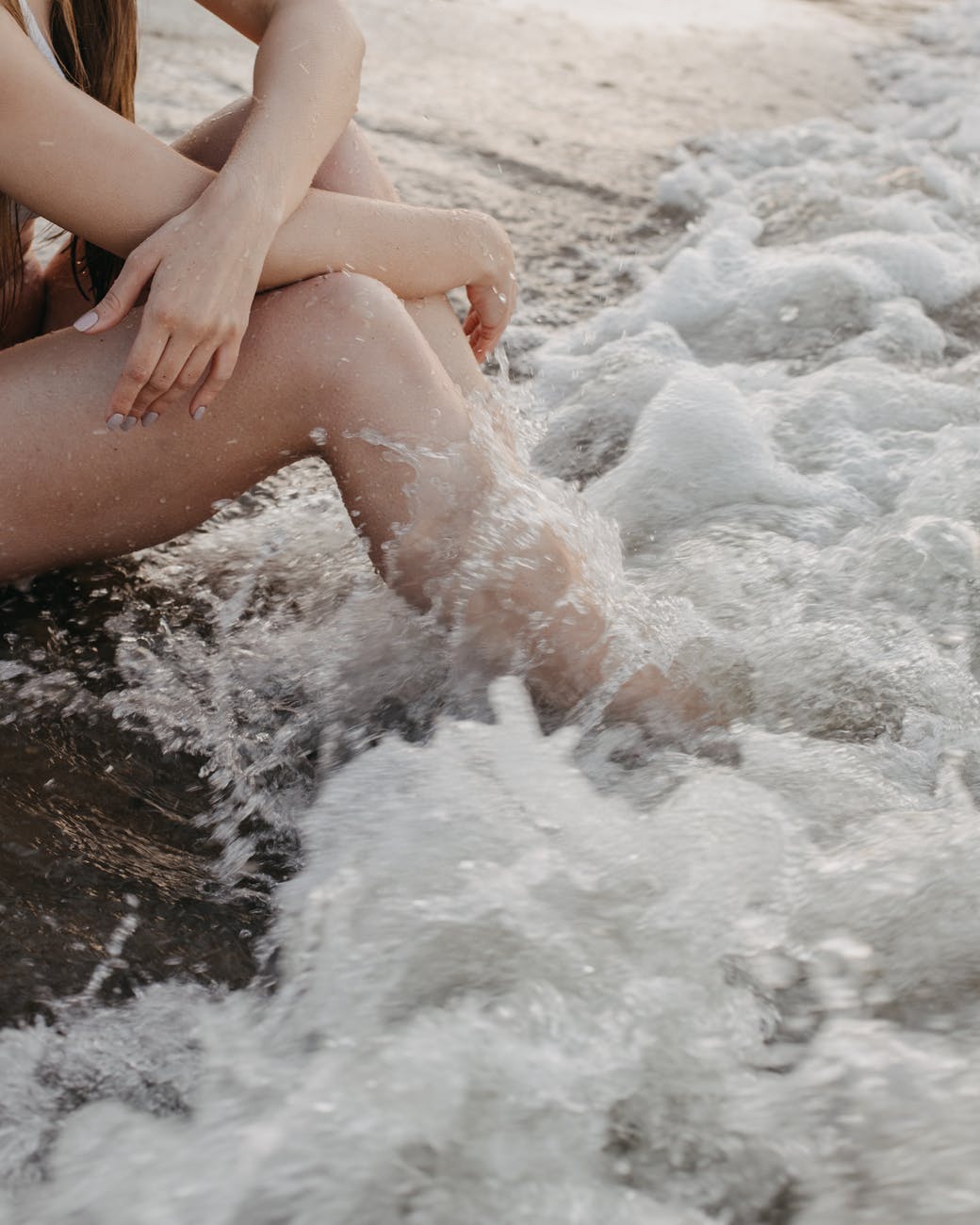 crop woman sitting near sea