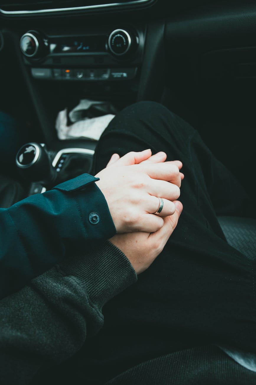 woman and man holding hands on car
