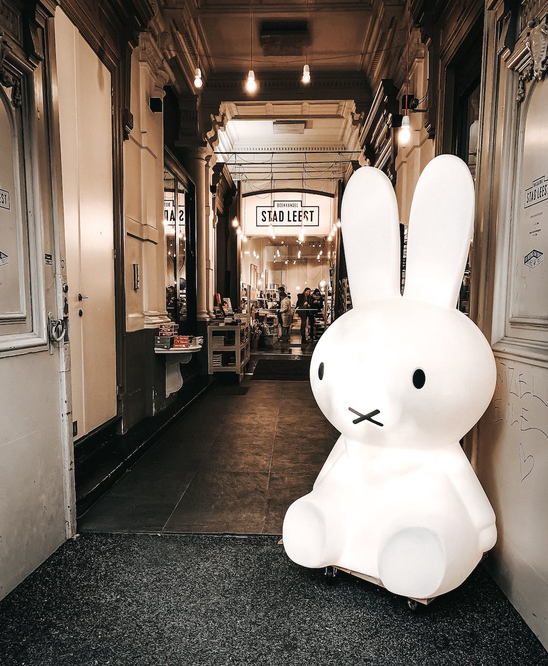 big white rabbit toy placed near entrance to shopping mall