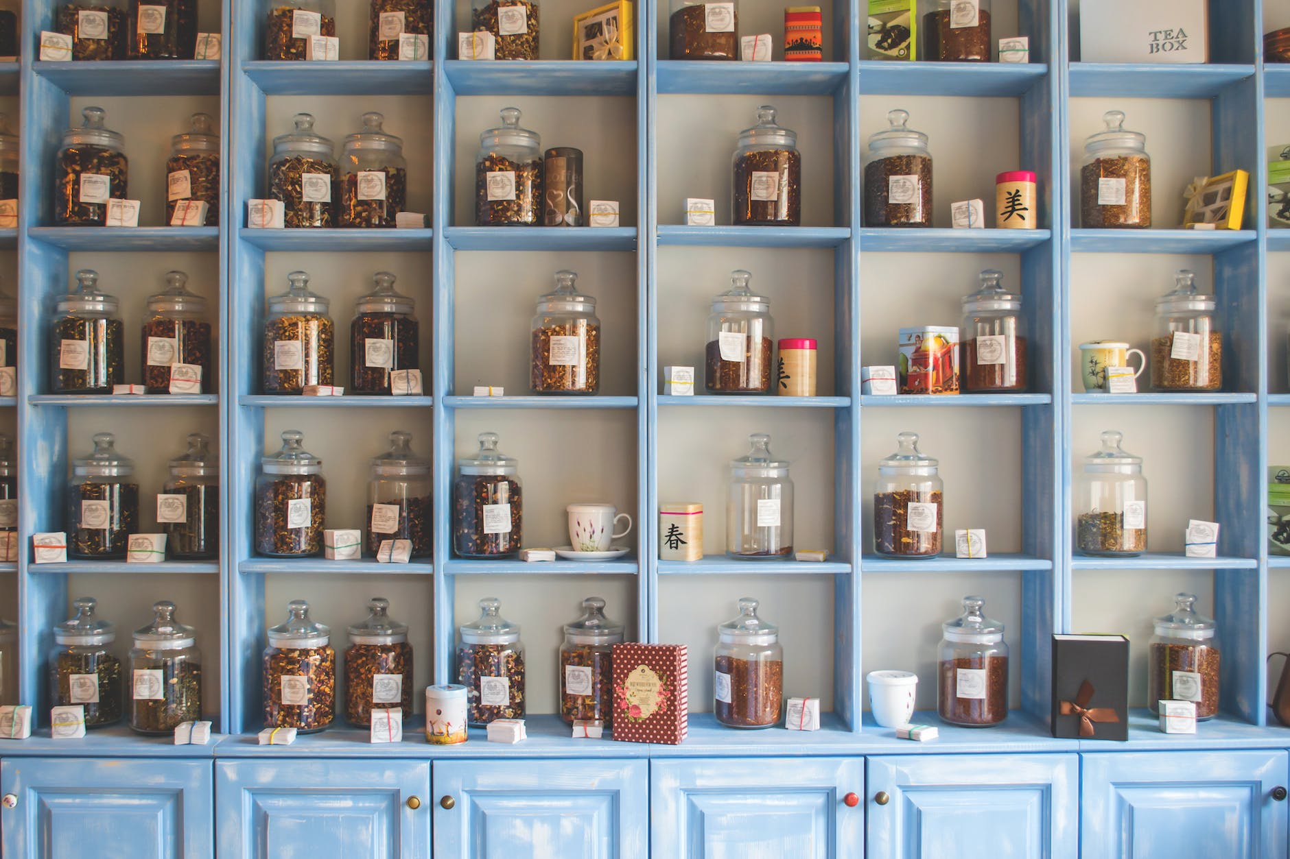 assorted jars on blue shelf cabinets